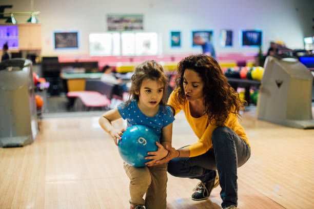 istock Woman teaching girl bowling 1157947663