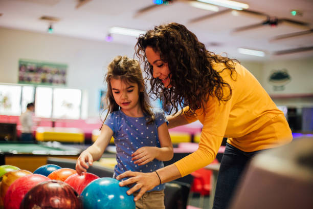 istock Woman teaching child bowling 1157948534