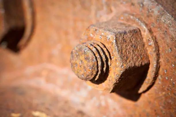 Photo of Old rusty bolt with threaded metal bar - image with copy space