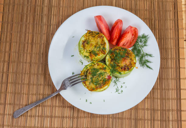 istock Top view of baked stuffed vegetable marrow pieces and fork 1157949243