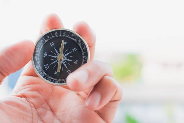 istock man holding compass on blurred background. for activity lifestyle outdoors freedom or travel tourism and inspiration backpacker alone tourist travel or navigator image. 1157949407