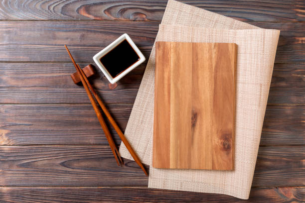 leere rechteckige holzplatte für sushi mit sauce und essstäbchen auf holztisch, ansicht von oben - bamboo brown cooking gourmet stock-fotos und bilder