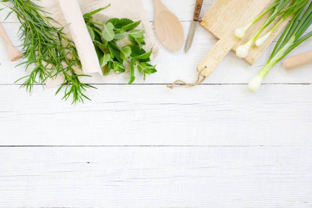 istock White wooden background with fresh greens and kitchenware 1157950453