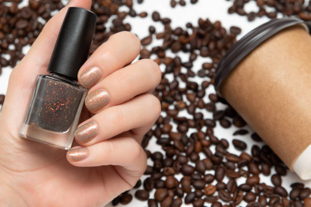 istock Female hands with glitter nail design holding paper cup. 1157950650