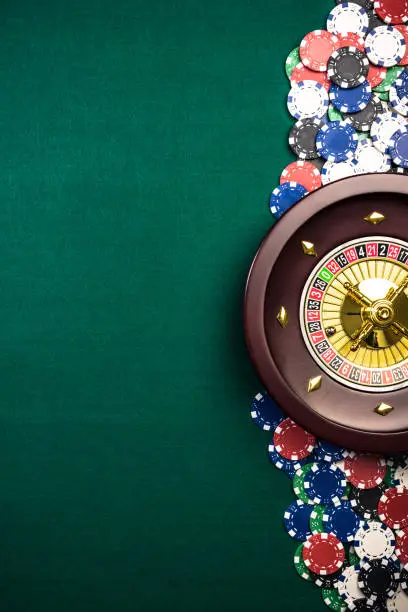 Casino Roulette Background with Roulette Drum,Casino Chips on Green Felt Table. Overhead View with Copy Space.