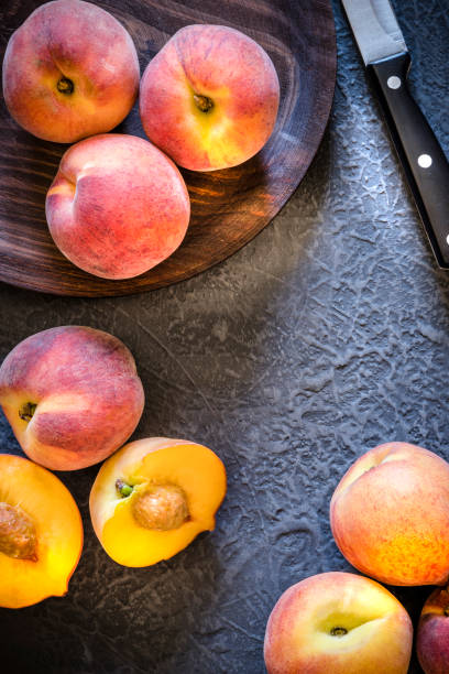 istock Whole and sliced peaches on dark gray textured background 1157954312