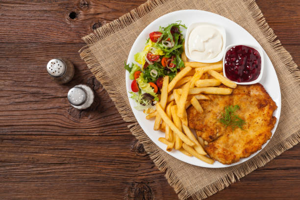 istock Chicken schnitzel, served with fries and salad. 1157954740