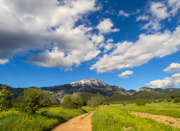 panoramic view of snow covered mountain dirfys, church candelakia  and sky with clouds on on the island of evia, greece - storm summer forest cloudscape imagens e fotografias de stock