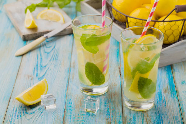 istock lemonade with mint on rocks served in a glass with a straw 1157956508