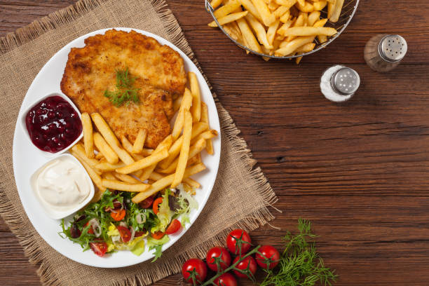 istock Chicken schnitzel, served with fries and salad. 1157956586
