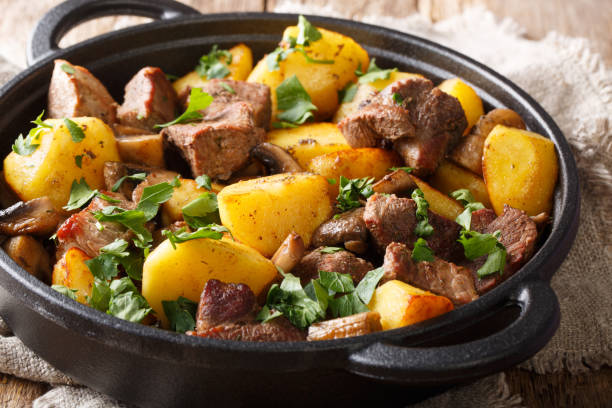 istock Fried potatoes with meat and mushrooms close-up on the table, rustic. horizontal 1157957914