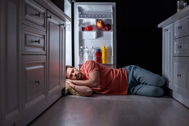 istock exhausted man sleeping near open refrigerator on kitchen floor 1157958068