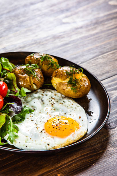istock Breakfast - fried egg, boiled potatoes and vegetable salad 1157959199