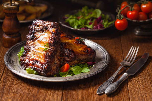 istock Roasted ribs, served on an old plate. Dark or balck background. 1157960254