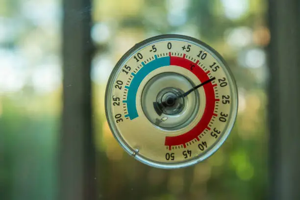 Photo of a thermometer of temperature outside the window that hangs on the window in the house
