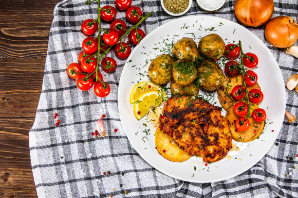 Roast chicken breast, baked potatoes and vegetables