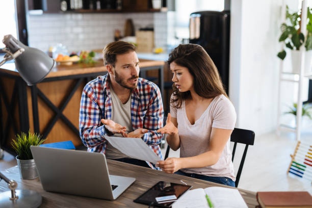 istock Frustrated couple checking bills at home using laptop 1157962276