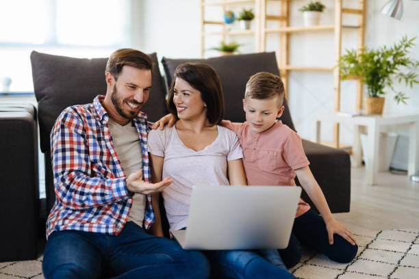 istock Happy family with little boy enjoying using laptop together 1157963444