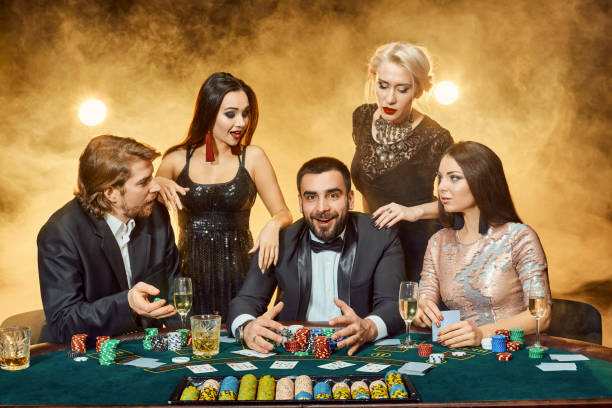 poker players sitting around a table at a casino. - smiling casino human hand beautiful imagens e fotografias de stock