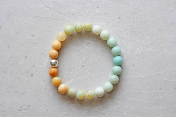 istock Bracelet from natural amazonite with gradients and silver bead. The bracelet on an elastic band, lies on a modern concrete light white background. Natural stones 1157965337