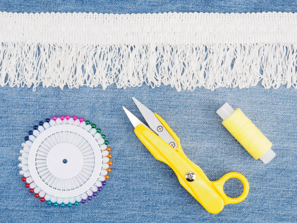 istock White lace, scissors, thread, pins on a jeans background. Sewing still life 1157965578