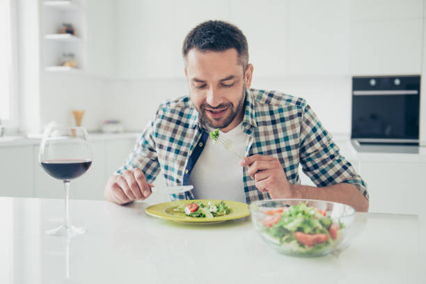 istock Portrait of charming imposing man hold hand silverware knife fork sit table enjoy meal morning breakfast checkered shirt clothes big light appartment room wineglass 1157965592