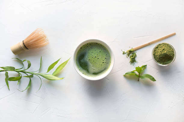 istock Ceremony green matcha tea and bamboo whisk on white concrete table. Top view. 1157966515