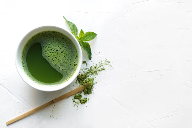 istock Ceremony green matcha tea and bamboo whisk on white concrete table. Top view. 1157966516