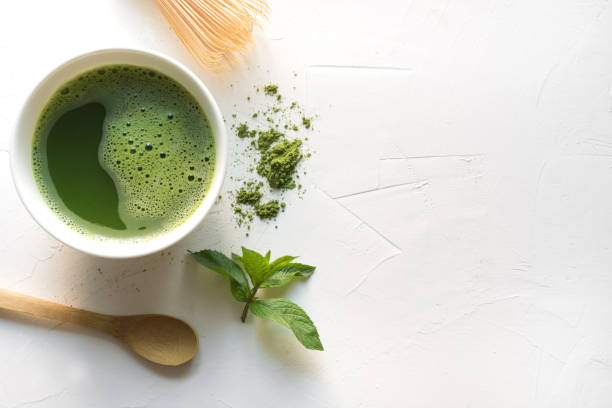 istock Ceremony green matcha tea and bamboo whisk on white concrete table. Top view. 1157966517