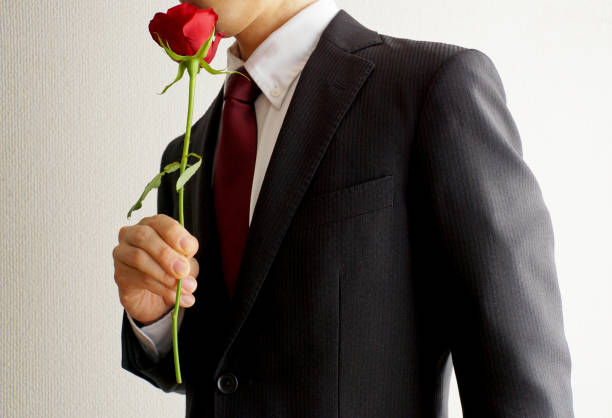 赤いバラの花を持つビジネスマン。 - handsome man ストックフォトと画像