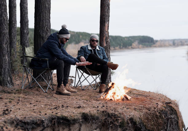 절벽에서 불에 의해 따뜻하게 하는 남성 친구 - russian ethnicity cold relaxation nature 뉴스 사진 이미지