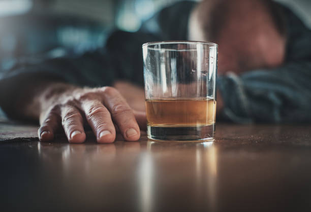 Troubled middle-aged man passes out as he drowns his sorrows in alcohol