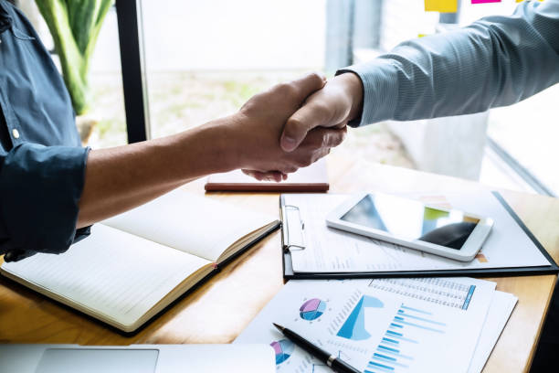 istock business man hands shaking together in office. 1157974061