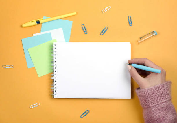 istock Write thoughts and ideas in a clean white notebook on an orange background 1157977824