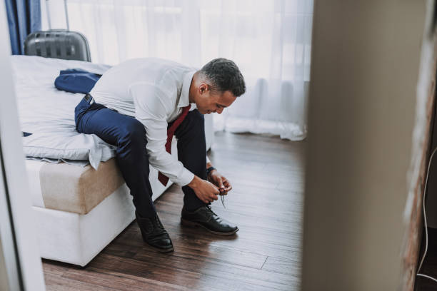 istock Smiling elegant man is dressing up before going to office 1157979727