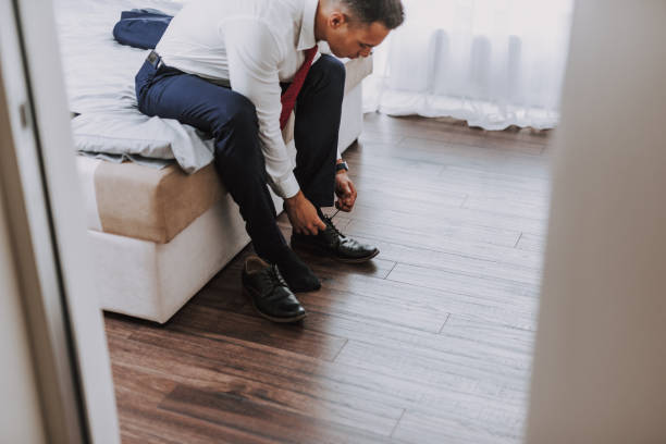 istock Young executive is putting on shoes in bedroom 1157979743