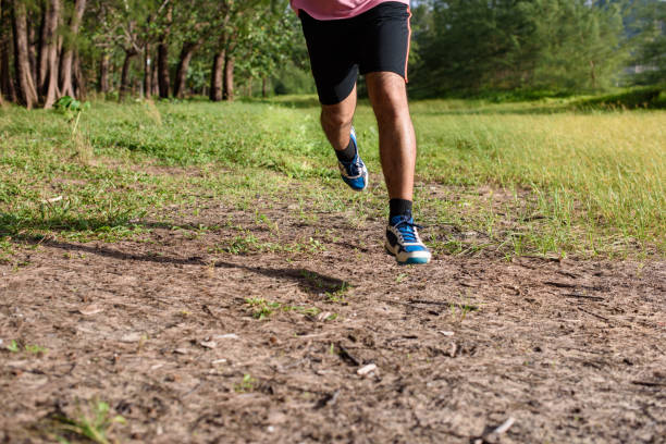 istock Asian Man running on forest path during sunset, close up legs and feet 1157981200