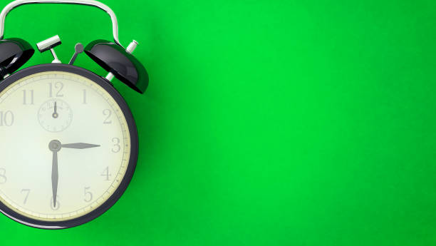 istock Vintage alarm clock on green background 1157981731