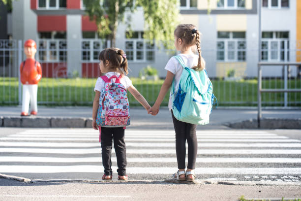 女子生徒、小学生、授業に行くバックパックを持って学校教育の概念に戻る - elementary school building ストックフォトと画像