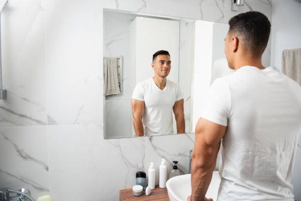 istock Back side of smiling young man looking at mirror 1157982995