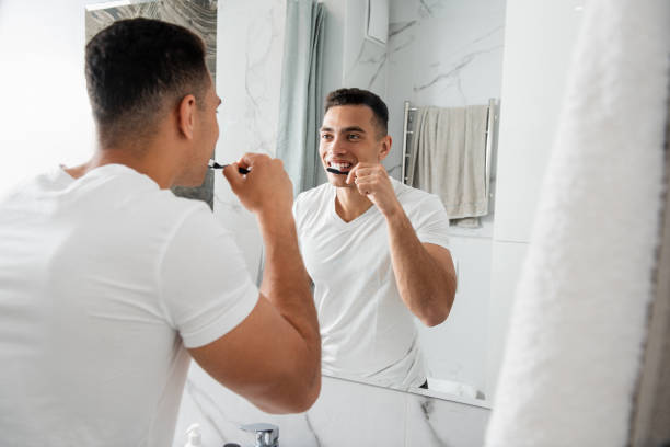 istock Back side of young man brushing his teeth 1157982998