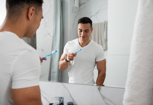 istock Young smiling man with tooth brush in bathroom 1157983005