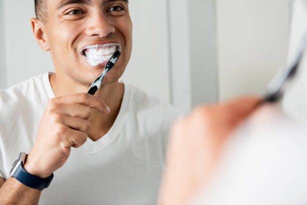istock Close up of young brunette man brushing teeth 1157983018