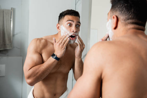 istock Young shocked man spreading shaving foam on face 1157983122