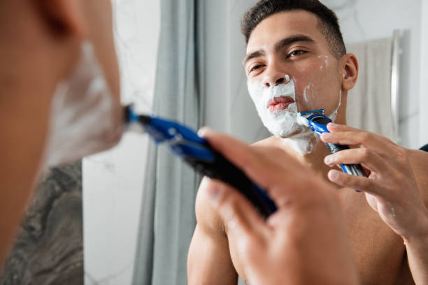 istock Young handsome man shaving himself by razor 1157983136