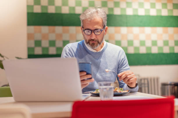 istock Bearded Businessman On Lunch Break In The Office And Using Smart Phone 1157983490