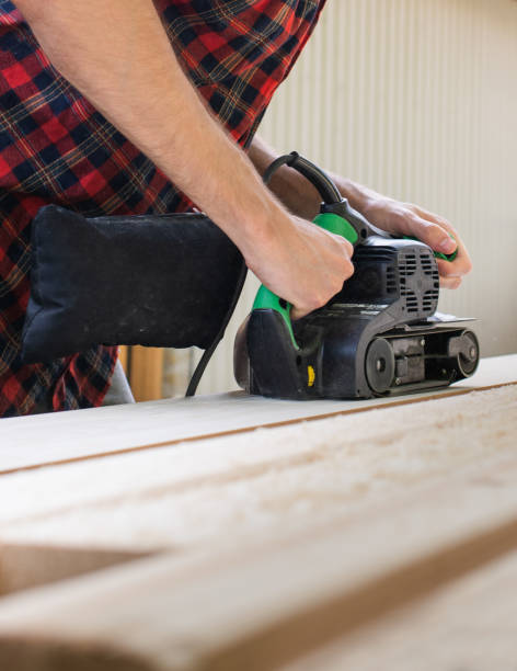 istock carpenter works with belt sander in carpentry 1157983659