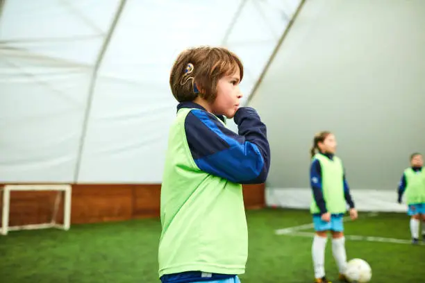 Photo of Cute Boy With Cochlea Implant At Kids Soccer Training