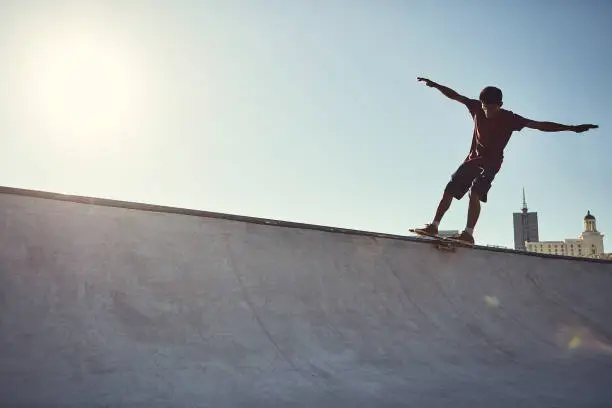 Full length shot of a young man doing tricks on his skateboard at a skate park