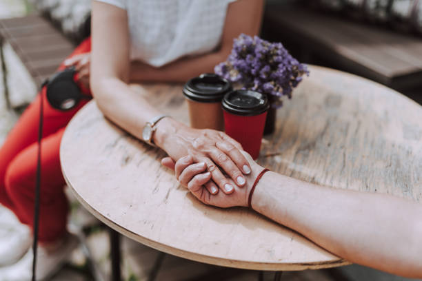 istock Man and woman holding hands in cafe 1157986528